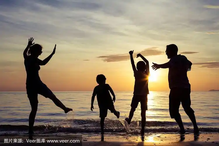 日落时分,幸福的一家人在海滩上玩耍.