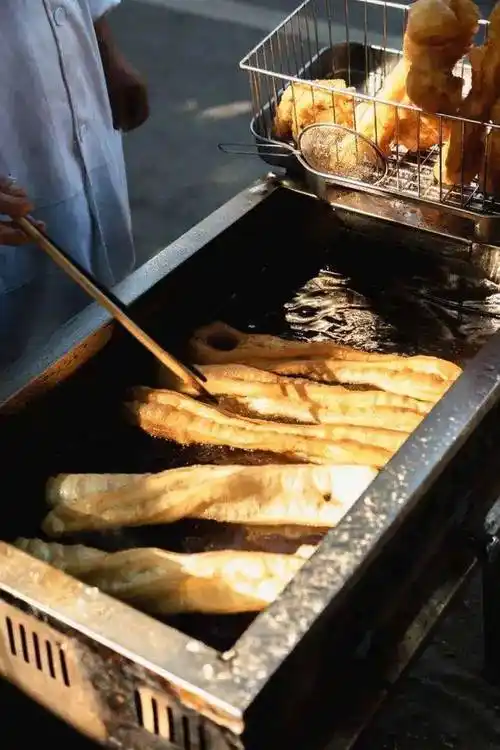 01这天,新上任的县长到小吃摊吃早餐,刚找个板凳坐下,就听炸油条的胡