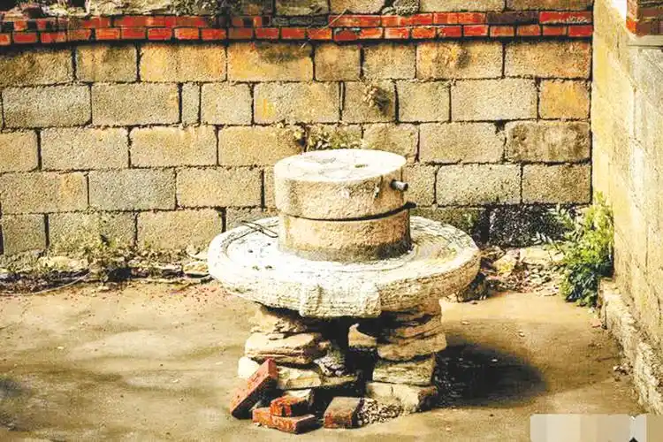 文/朱晓吾节日放假回老家,一进院子就看到我家那盘闲置的古老的石磨.