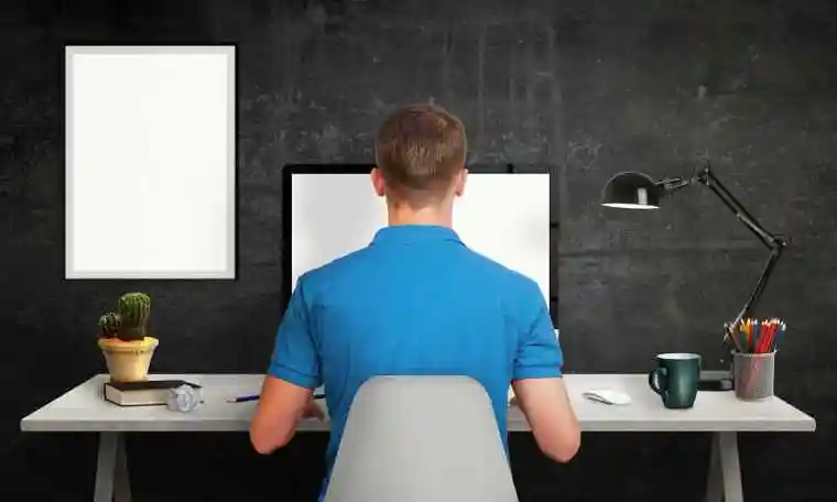 黑色房间内对着电脑的男人背影