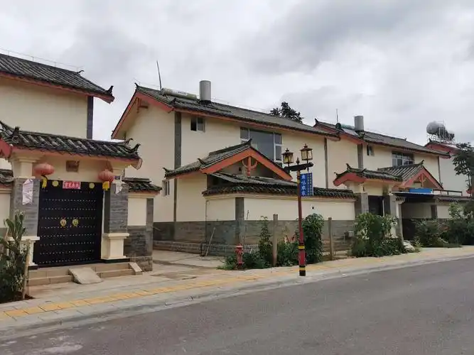 彝族第一村,房子不高,两层结构,外部统一风格,内部各具特色,民族元素