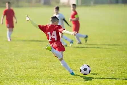 小孩足球足球-孩子们演员比赛向足球田照片