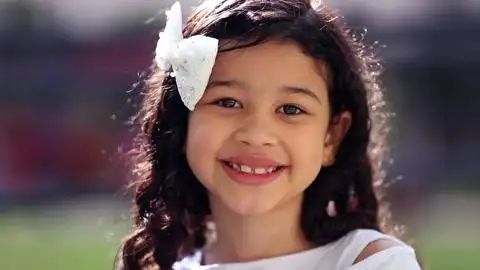 西班牙小女孩在户外对着镜头微笑亚洲拉丁混血儿