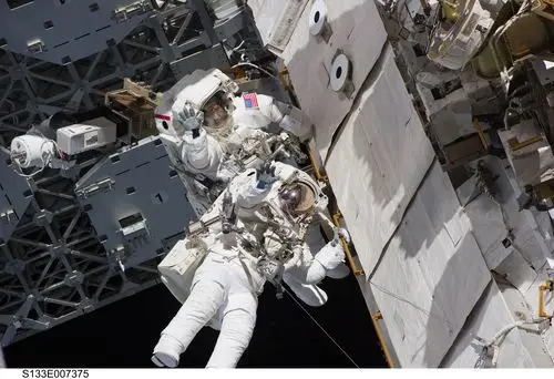two astronauts,spacewalk,space shuttle,discovery,tools,suit,pack