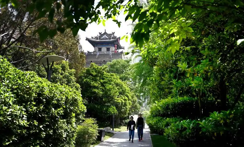 市民在西安明城墙下的环城公园内散步(4月25日摄).