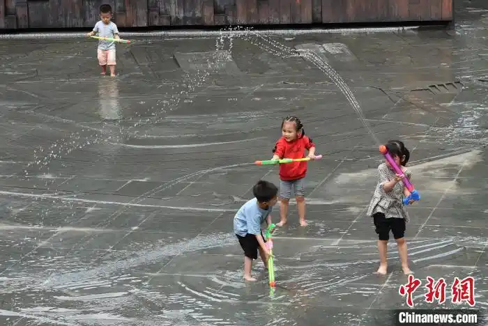图为不少家长带着小孩在三峡景观水景处戏水纳凉. 周毅 摄