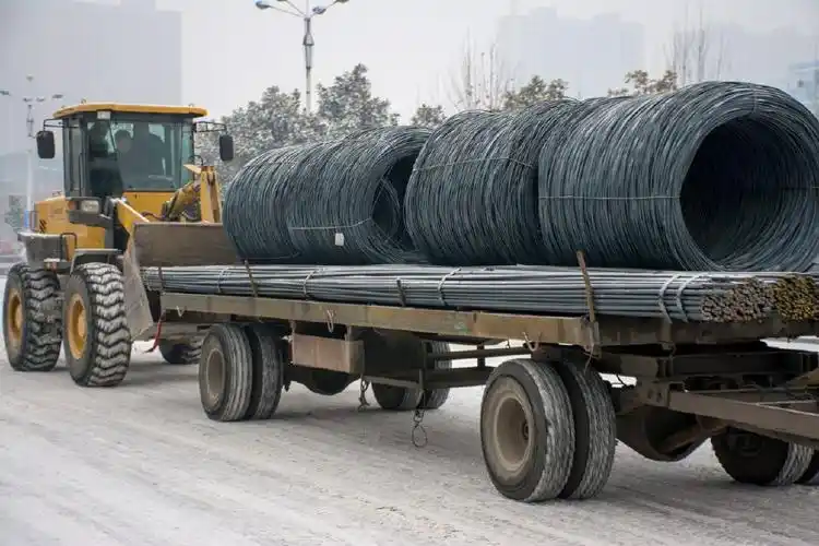 雪地上一台小型拖拉机拉了几十吨钢筋原地打滑,推土机背后帮了忙