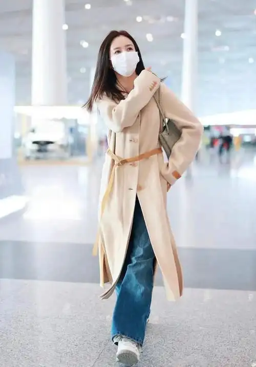 前段时间佟丽娅的机场私服,就穿着一件米色羊绒大衣搭配牛仔裤,简约不