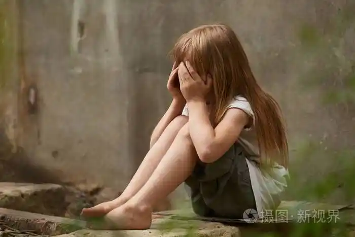 在肮脏的城墙下holen膝的哭泣的女孩孤儿画像