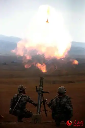 演习期间,红方迫击炮分队向蓝军阵地发射炮弹.