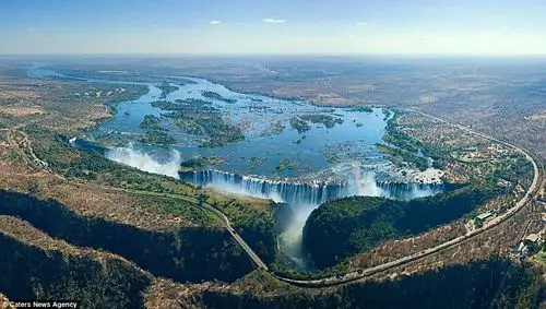 a rainbow perfectly captured at the victoria falls in zambia