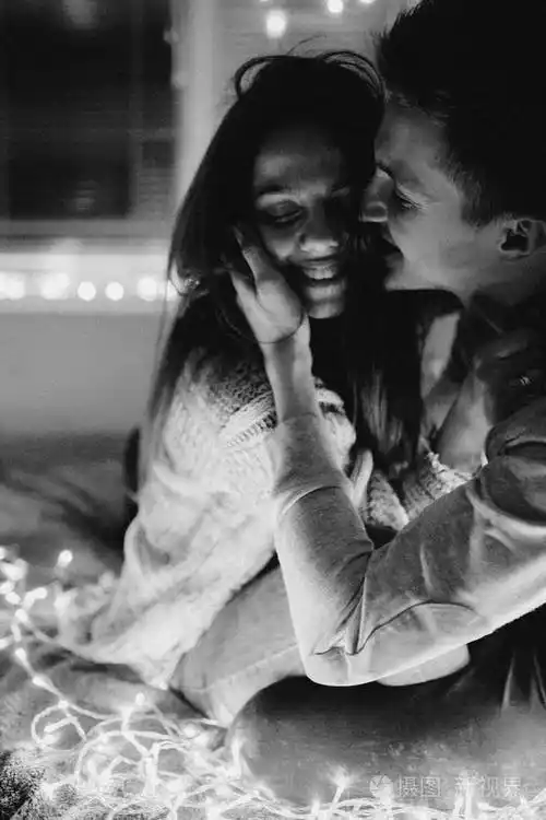 相爱的情侣在卧室的花环上互相拥抱黑白照片带噪音过滤器