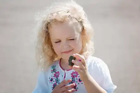 看鹅小女孩眯着眼睛看着鹅卵石照片