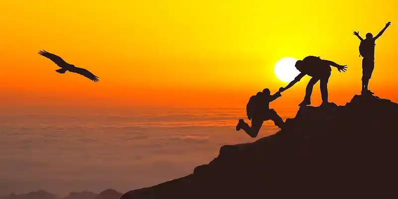 团队凝聚力  凝聚力蓝色光晕登山剪影活动展板背景攀登山顶的人物