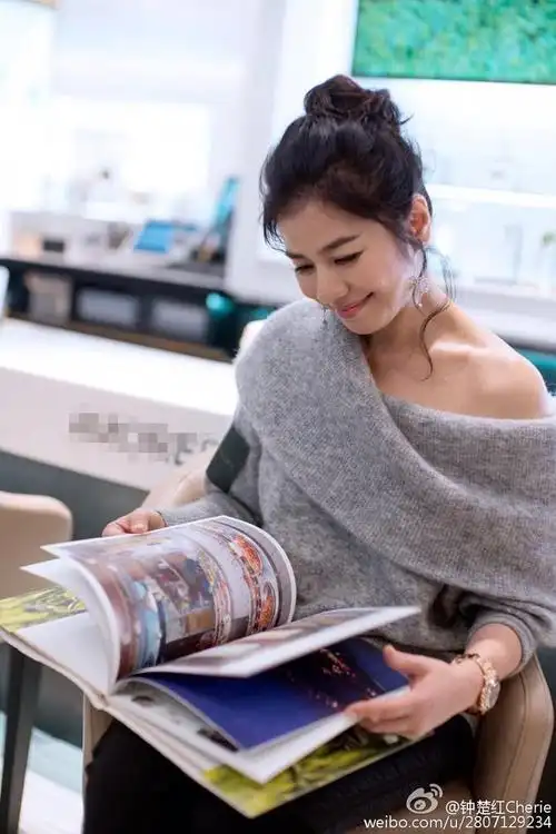 钟楚红梳减龄丸子头看影集 露肩美艳动人