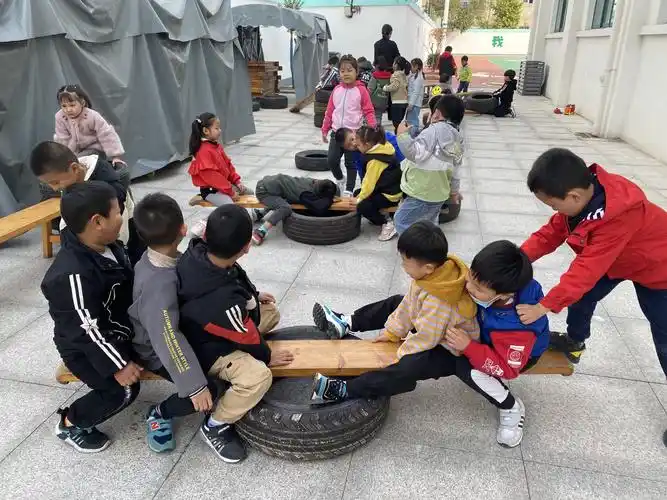 孩子们在自制跷跷板上玩的非常开心