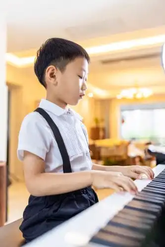 亚洲中国男孩认真地练习弹钢琴