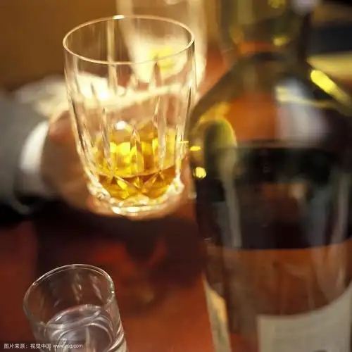 在酒吧里拿着一杯威士忌的手