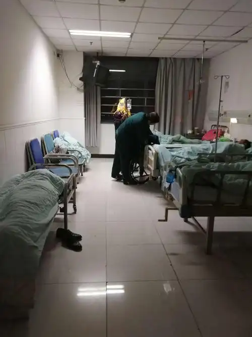 运送中心夜班人员陈寿海为病区刚入院病人轮椅陪检.