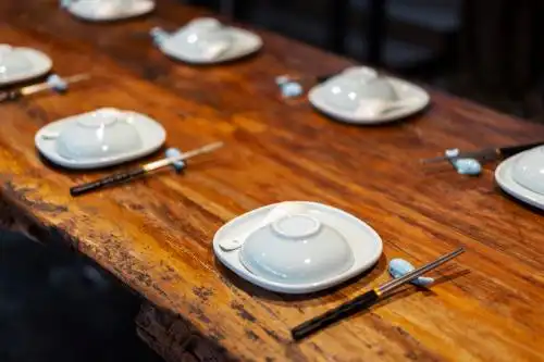 餐厅里木桌上摆放整齐的餐具