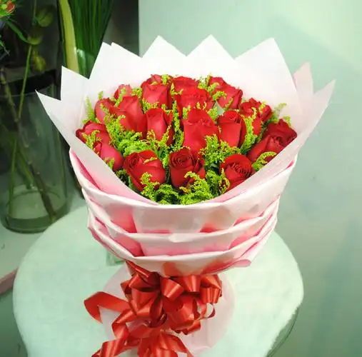 鲜花细节21朵红玫瑰,搭配绿叶;粉色包装纸,红色花结