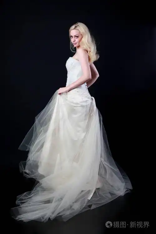 穿白色新娘礼服的模特全长肖像, 黑色背景站立姿势