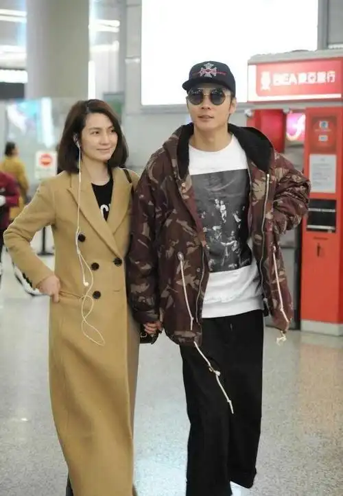 洪欣携老公走机场,穿卡其色大衣高级大气,素颜也看不出差10岁