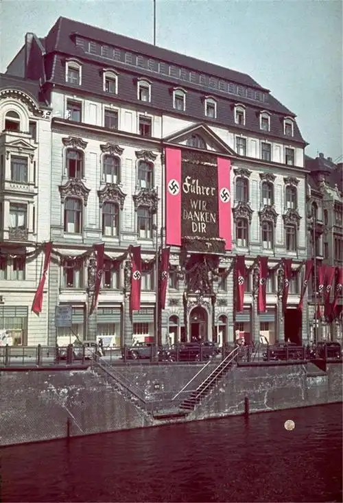 照片拍摄于二战时期,德国柏林的繁华街景,建筑物上挂满了纳粹卐字旗