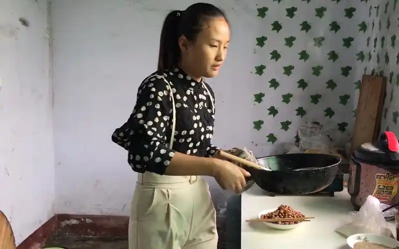 农村媳妇在家做小零食花生米里面加上一个鸡蛋出锅后脆甜可口