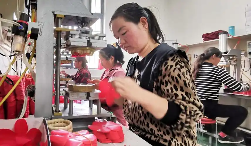 4月19日,洛南县巧手工艺品有限公司员工在车间加工草编配套产品.