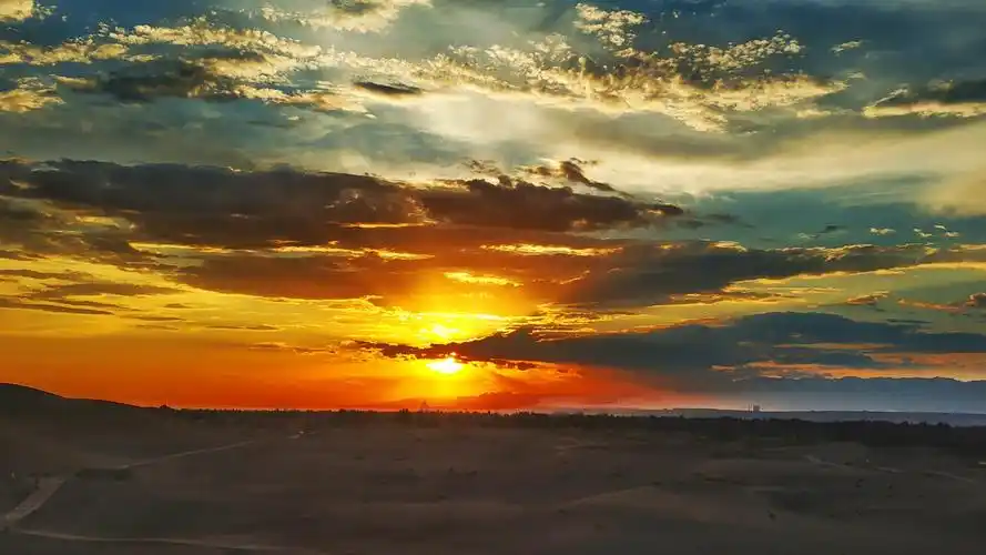 暮霭溶于晚霞,夕阳绚烂落幕,此时才依依惜别库木塔格沙漠.