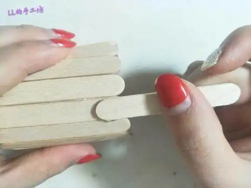 在雪糕棍上涂上热熔胶,再竖着粘上一根雪糕棍,并在相对称的另一边也