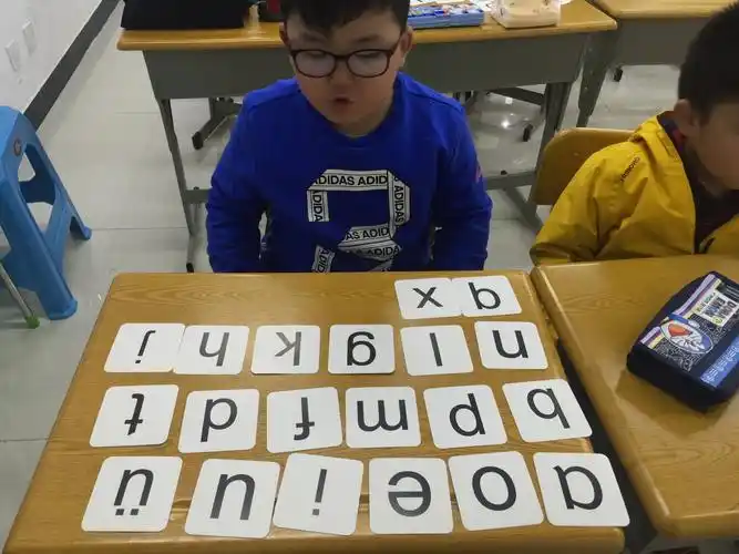 我们用拼音牌玩游戏:排卡片,听音举牌,摸牌.