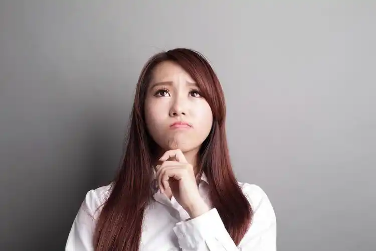 在灰色背景下思考的女人思维