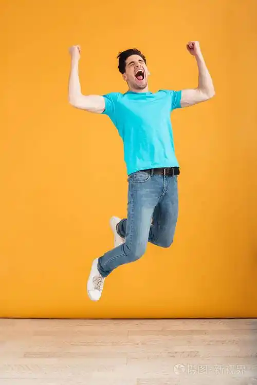 一个欢快的年轻人跳的全长肖像