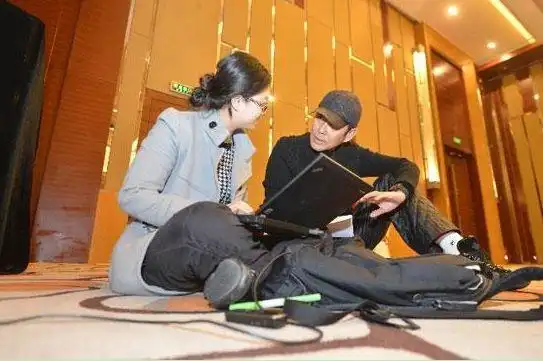 图为陈道明和采访记者在讨论稿件(新浪网  实习生邓宇澄 整理报道)