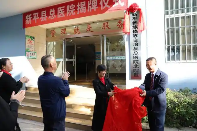 全体与会人员移步至综合楼门前参加新平县总医院揭牌仪式,县人民政府