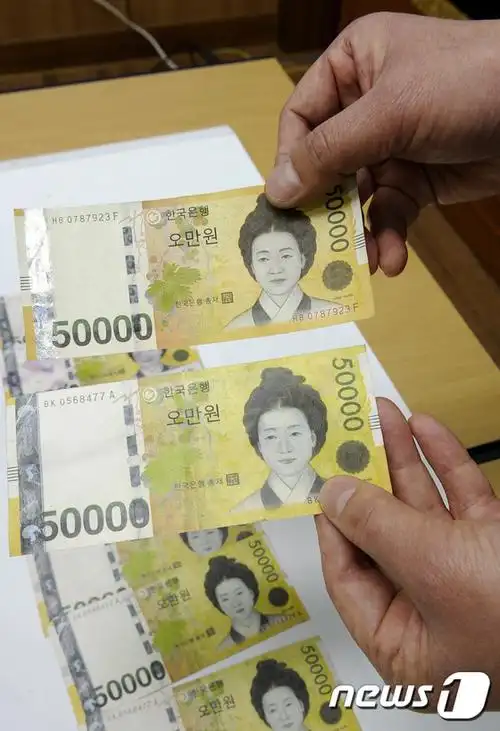 警方展示面值五万韩元的真币和假币,下方为假钞.