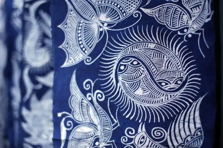 蜡染工艺品的魅力除了图案精美外,还在于蜡冷却后在织物上产生龟裂