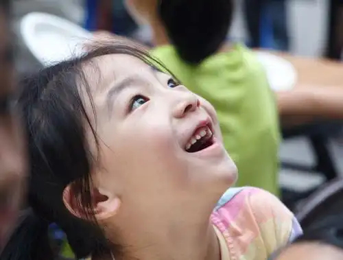 这位候场的小女孩看到什么了?笑得多甜美!