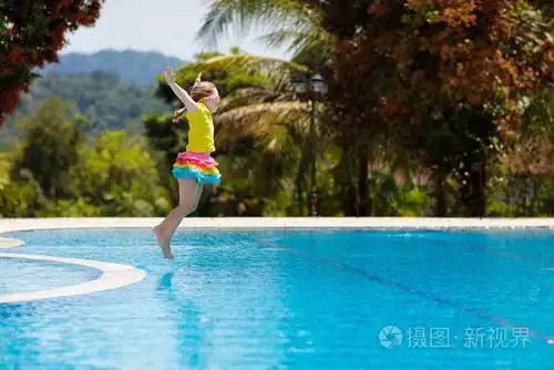 小女孩在热带岛屿度假胜地的异国情调度假期间跳进水里. 孩子们游泳.