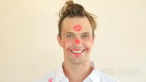 上的口红印勒芒衣领.一名年轻男子的画像.他整个的脸上布满痕迹的吻.