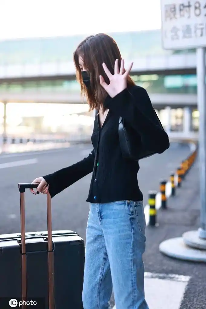 1/ 12 北京,刘雯机场街拍,黑色针织开衫搭配牛仔裤加腋下包简约高级.