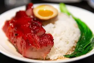 黑色餐桌上的一盘港式叉烧饭