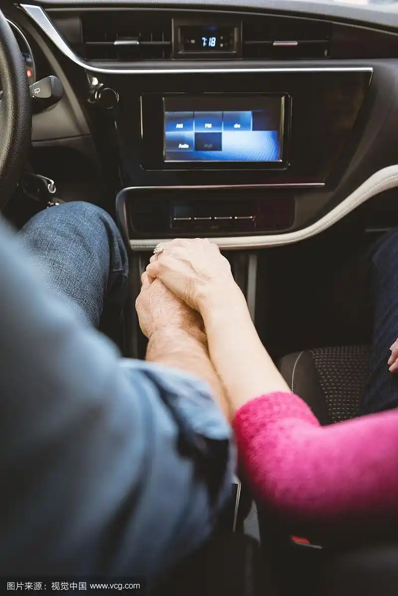 开车时手拉手的夫妇