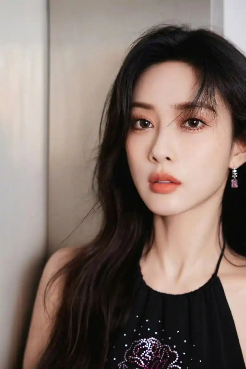 只见她身穿黑色皮衣,长发飘飘,红唇诱人,露肩上衣和短裤展示出她的