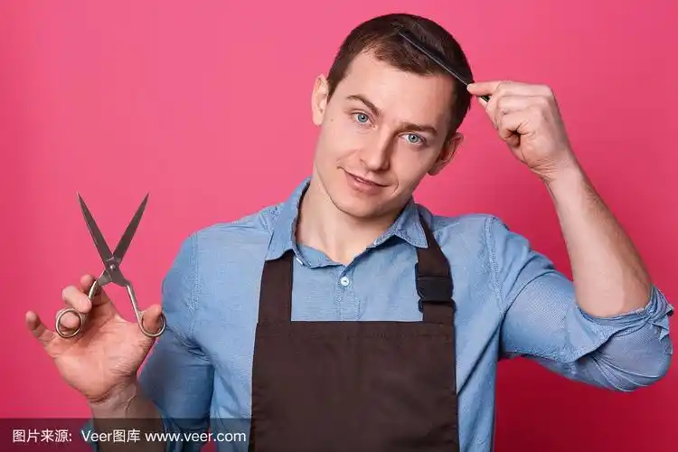 专业的男理发师手里拿着剪刀,自己梳,穿着蓝衬衫,棕色围裙,在理发店或
