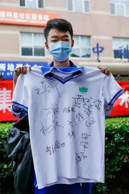 7月10日,在北京中关村中学考点外,考生何瑞展示同学们在他校服上的