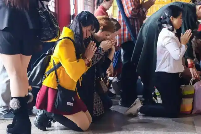 虔诚的信众,跪拜菩萨,静默许下心愿.