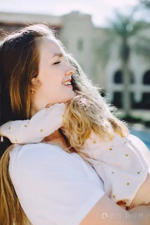 快乐的母亲拥抱她可爱的小女儿